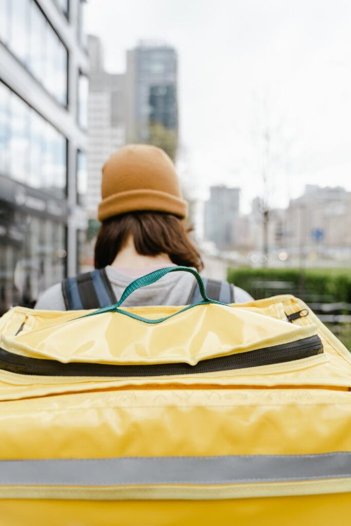 Person Wearing a Beanie Carrying a Yellow Bag